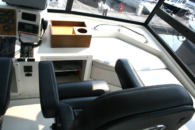Slide: The Image of Interior helm of 1989 Silverton 34 Convertible yacht with black seats and control panel. - 9