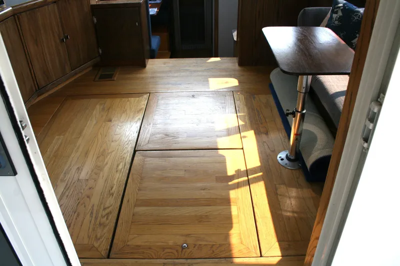 Slide: The Image of Interior of 1989 Silverton 34 Convertible boat with wooden flooring and compact seating area. - 25