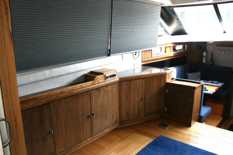 Slide: The Image of Interior of 1989 Silverton 34 Convertible yacht with wood cabinetry and seating area. - 13