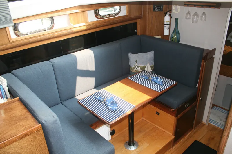 Slide: The Image of Interior of 1989 Silverton 34 Convertible yacht with cozy dining area and nautical decor. - 16