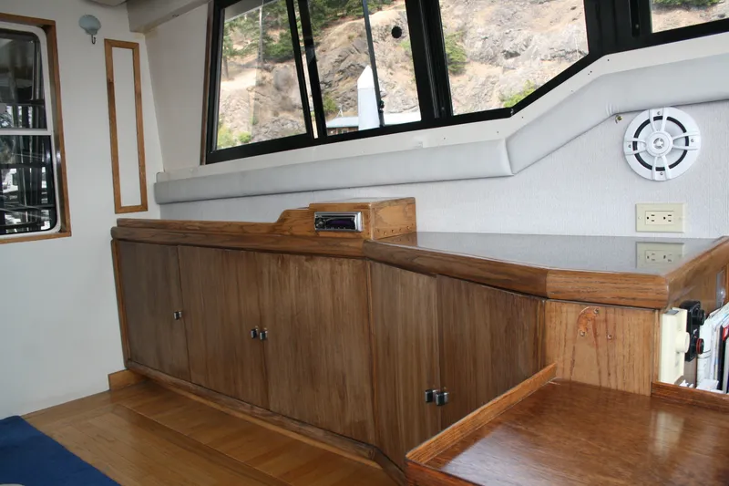 Slide: The Image of Interior of 1989 Silverton 34 Convertible yacht with wooden cabinetry and large windows. - 14