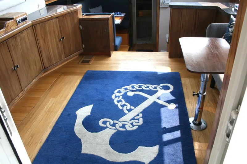 Slide: The Image of Interior of 1989 Silverton 34 Convertible with nautical-themed rug and wooden cabinetry. - 24