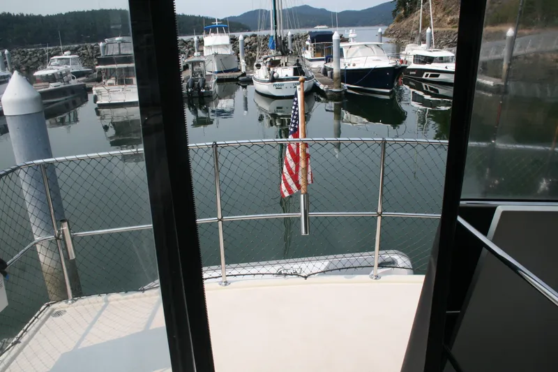 Slide: The Image of 1989 Silverton 34 Convertible yacht docked in a scenic marina with American flag. - 10