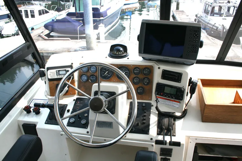 Slide: The Image of 1989 Silverton 34 Convertible helm with steering wheel, gauges, and navigation equipment. - 5