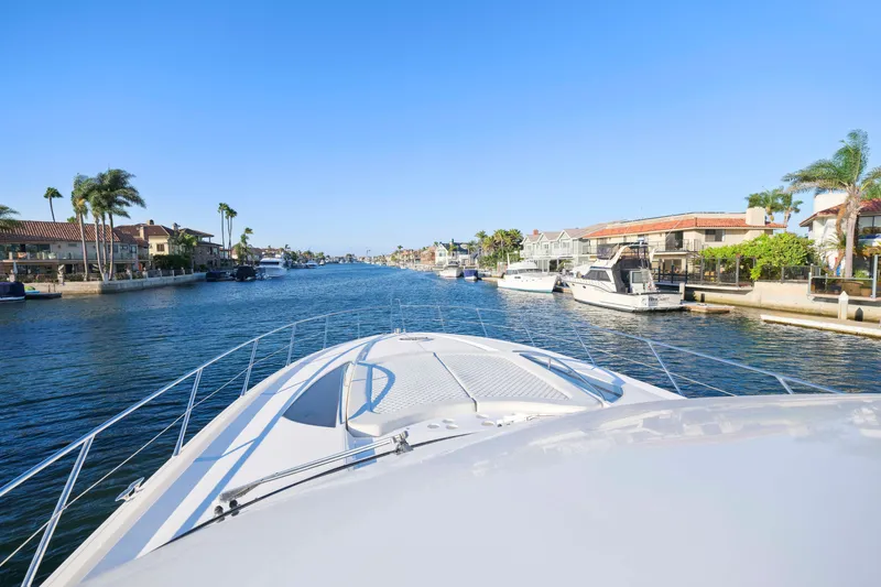 Slide: The Image of Front view of a 2006 Sunseeker Predator 68 yacht cruising through a scenic canal. - 15