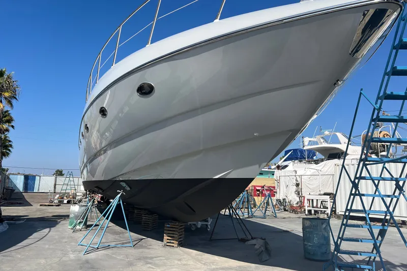 Slide: The Image of Sunseeker Predator 68 yacht, 2006 model, in dry dock for maintenance under clear blue sky. - 42