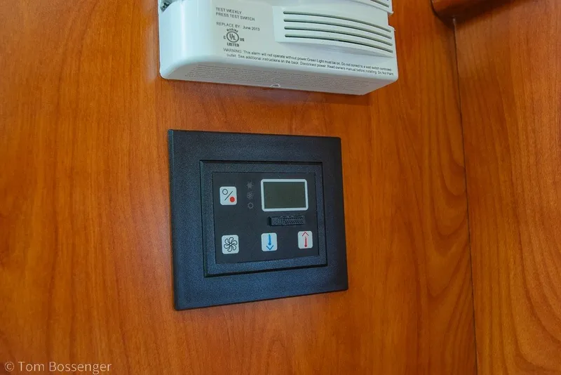 Slide: The Image of Control panel and smoke detector on 2012 Rinker 310 Express Cruiser's wooden interior. - 21