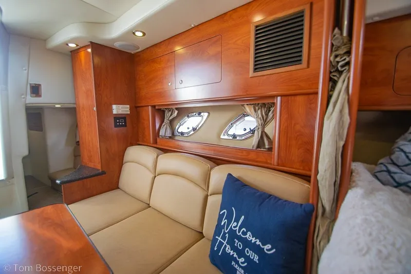 Slide: The Image of Interior of 2012 Rinker 310 Express Cruiser with cozy seating and wooden cabinetry. - 18