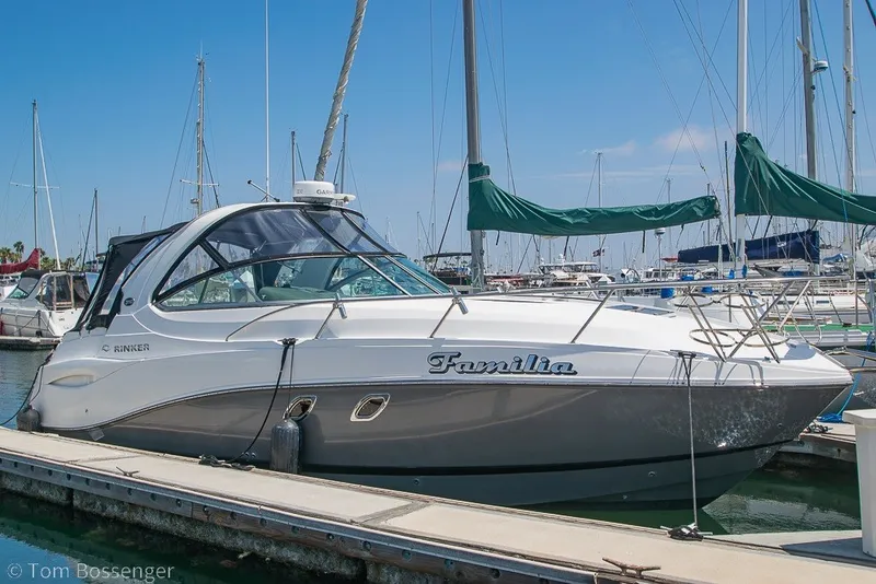 The Image of 2012 Rinker 310 Express Cruiser docked at marina, sunny day. - 0