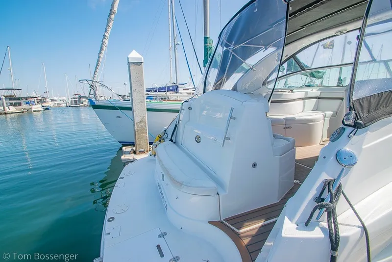 Slide: The Image of 2012 Rinker 310 Express Cruiser docked at marina, showcasing sleek design and spacious seating. - 41