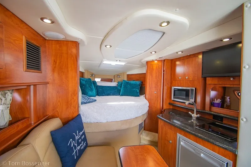 Slide: The Image of Luxurious interior of 2012 Rinker 310 Express Cruiser with cozy bed and modern kitchenette. - 15