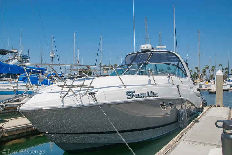 Slide: The Image of 2012 Rinker 310 Express Cruiser docked at a marina under clear blue skies. - 4
