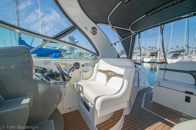 Slide: The Image of Interior of a 2012 Rinker 310 Express Cruiser with helm and seating area. - 32