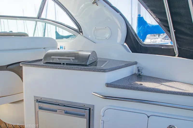 Slide: The Image of Interior of 2012 Rinker 310 Express Cruiser with kitchenette and seating area. - 37