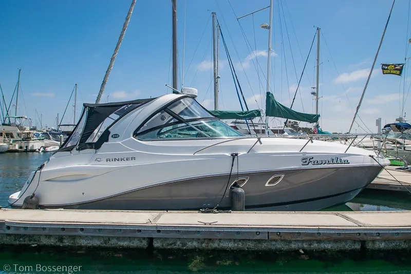 Slide: The Image of 2012 Rinker 310 Express Cruiser docked at marina under clear blue sky. - 1