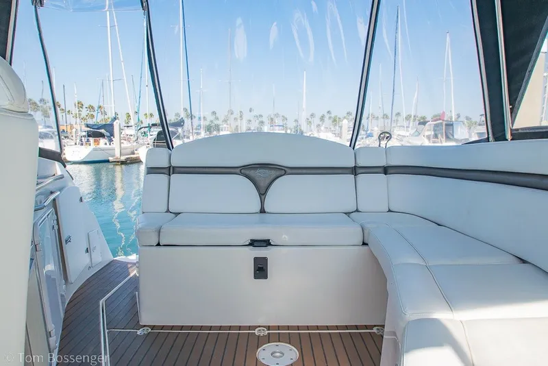 Slide: The Image of Interior of 2012 Rinker 310 Express Cruiser with white seating and marina view. - 40