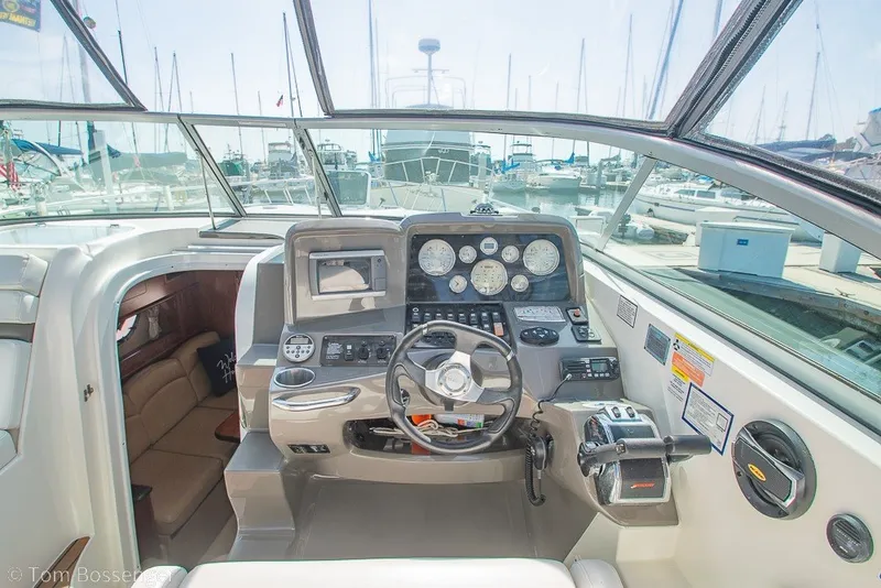 Slide: The Image of Cockpit of 2012 Rinker 310 Express Cruiser with steering wheel and control panel. - 33