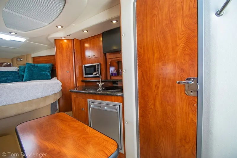 Slide: The Image of Interior of 2012 Rinker 310 Express Cruiser with wood finishes and modern amenities. - 17