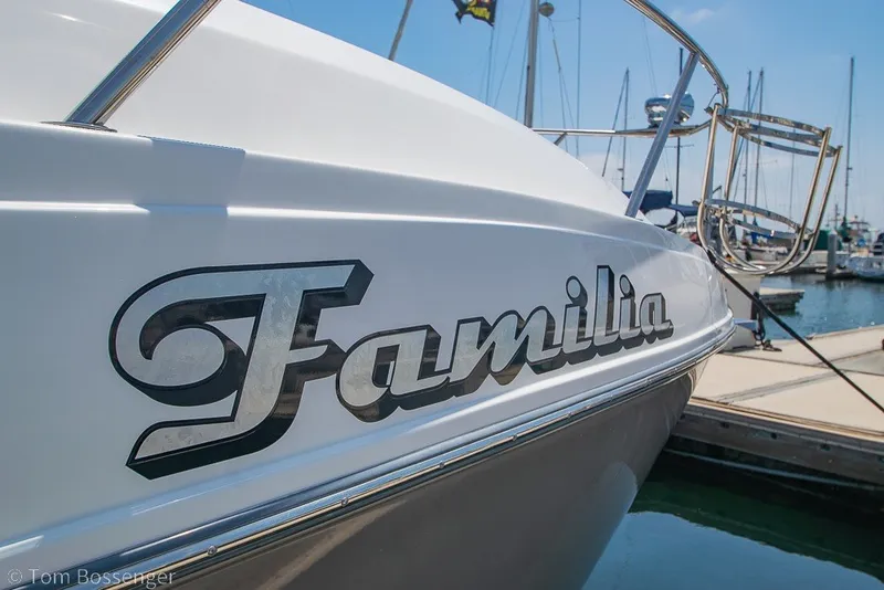 Slide: The Image of 2012 Rinker 310 Express Cruiser named "Familia" docked at a marina. - 6