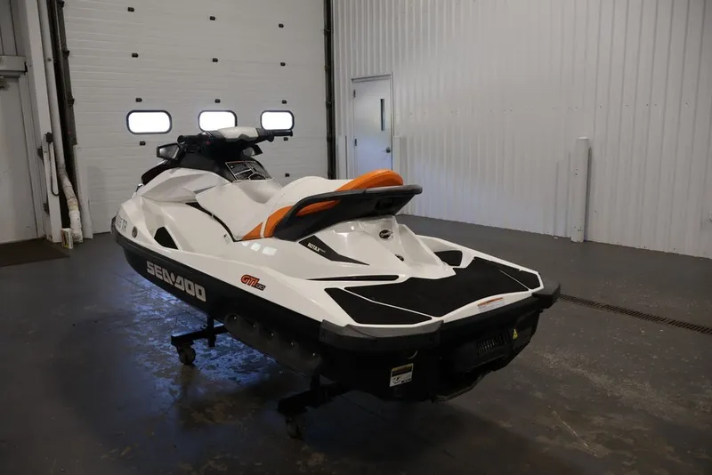 Slide: The Image of 2014 Sea-Doo GTI 130 jet ski in a garage, showcasing sleek design and vibrant colors. - 17