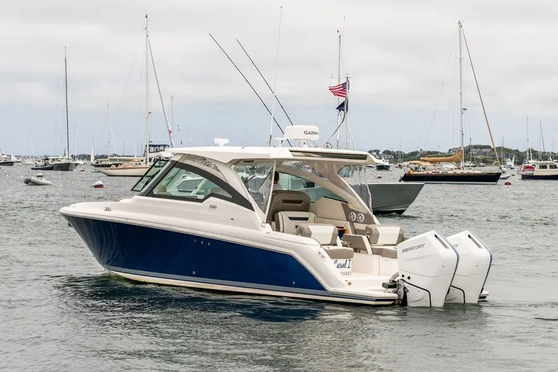 Slide: The Image of 2024 Tiara Yachts 34 LX in harbor, featuring sleek design and dual Mercury engines. - 6