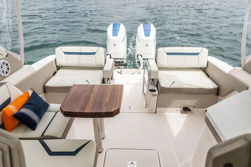 Slide: The Image of 2024 Tiara Yachts 34 LX interior with seating, table, and twin outboard motors on water. - 35