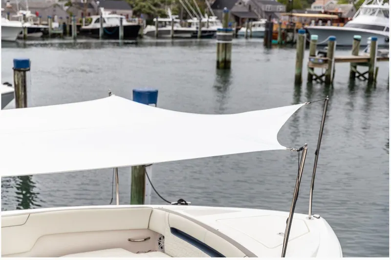 Slide: The Image of 2024 Tiara Yachts 34 LX with sunshade, docked in a marina. - 10