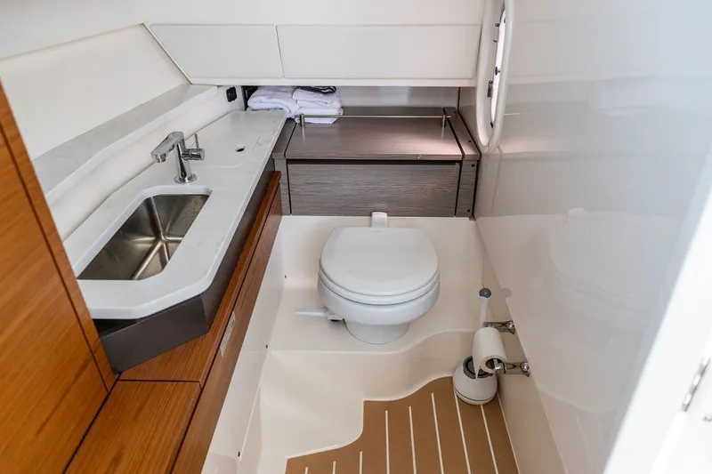 Slide: The Image of 2024 Tiara Yachts 34 LX bathroom with modern sink, toilet, and wooden cabinetry. - 42