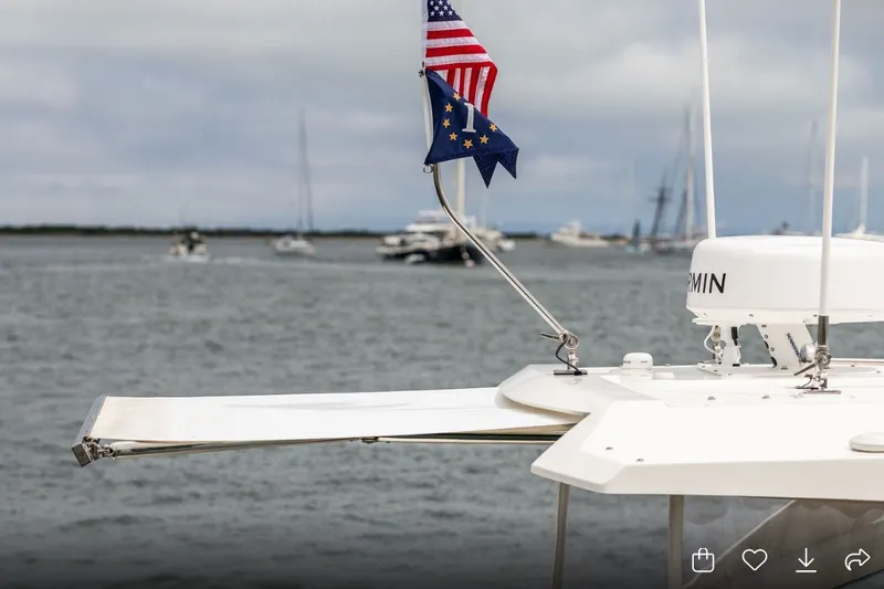 Slide: The Image of 2024 Tiara Yachts 34 LX with flags, docked in a serene harbor. - 9