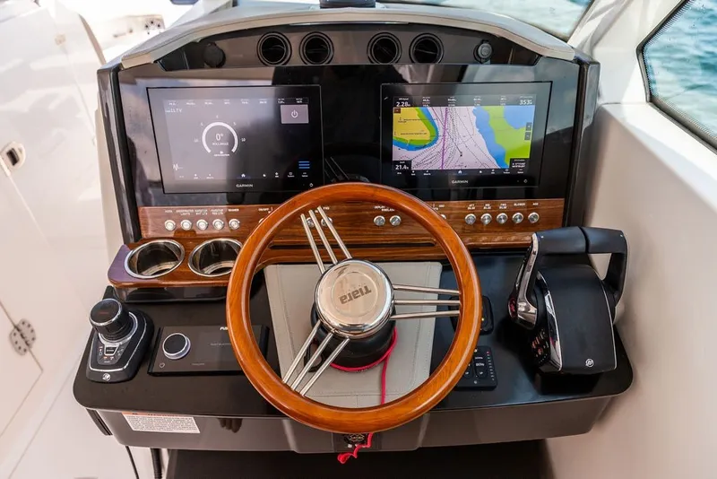 Slide: The Image of 2024 Tiara Yachts 34 LX helm with dual displays and wooden steering wheel. - 3