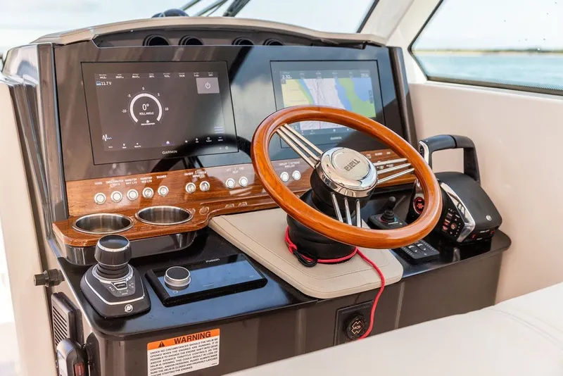 Slide: The Image of 2024 Tiara Yachts 34 LX helm with modern controls and wooden steering wheel. - 19