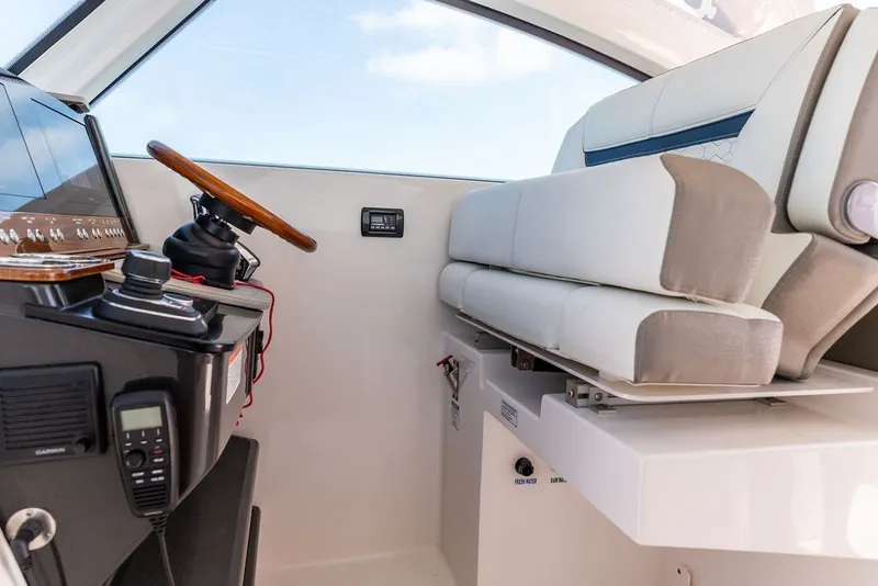 Slide: The Image of 2024 Tiara Yachts 34 LX helm with modern controls and plush seating. - 18
