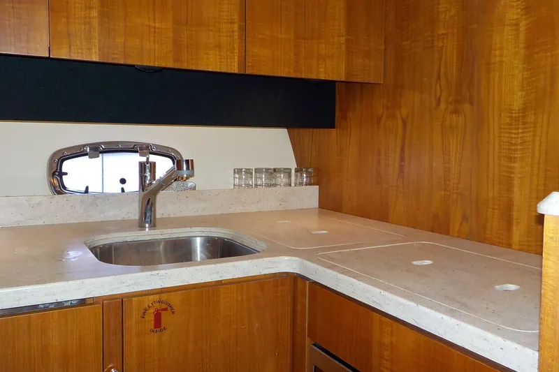 Slide: The Image of 2009 Tiara Yachts 3900 Open kitchen with wooden cabinets and stainless steel sink. - 33