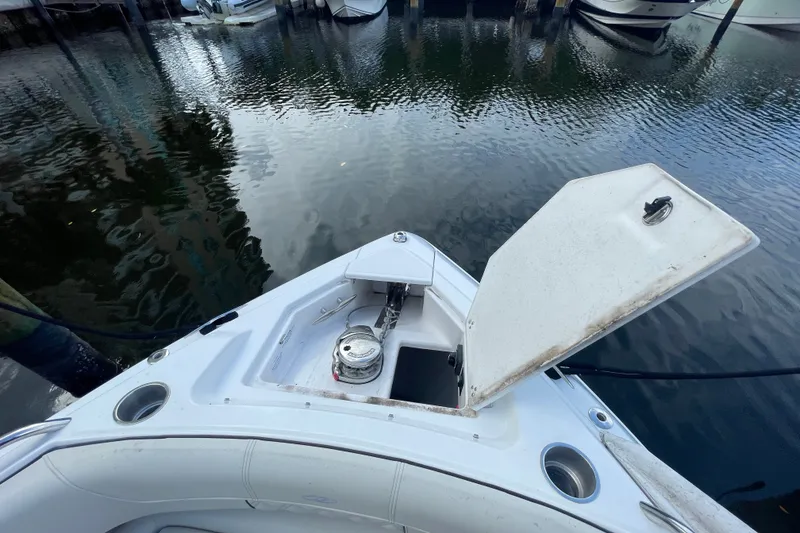 Slide: The Image of 2022 Regal 33 SAV boat with open anchor compartment, docked in calm waters. - 19