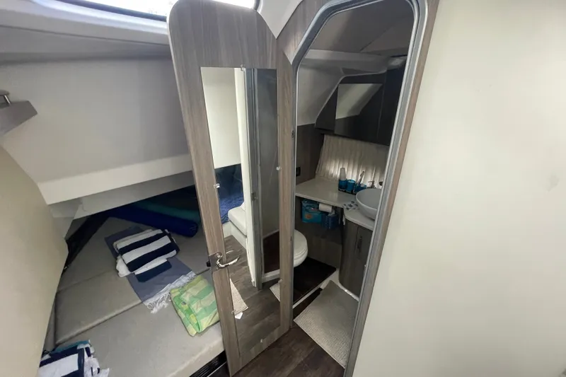 Slide: The Image of Interior of 2022 Regal 33 SAV boat featuring cabin and compact bathroom. - 24