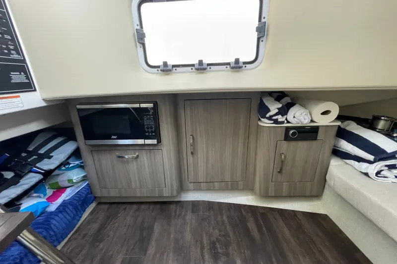 Slide: The Image of Interior of 2022 Regal 33 SAV boat with microwave and storage cabinets. - 23