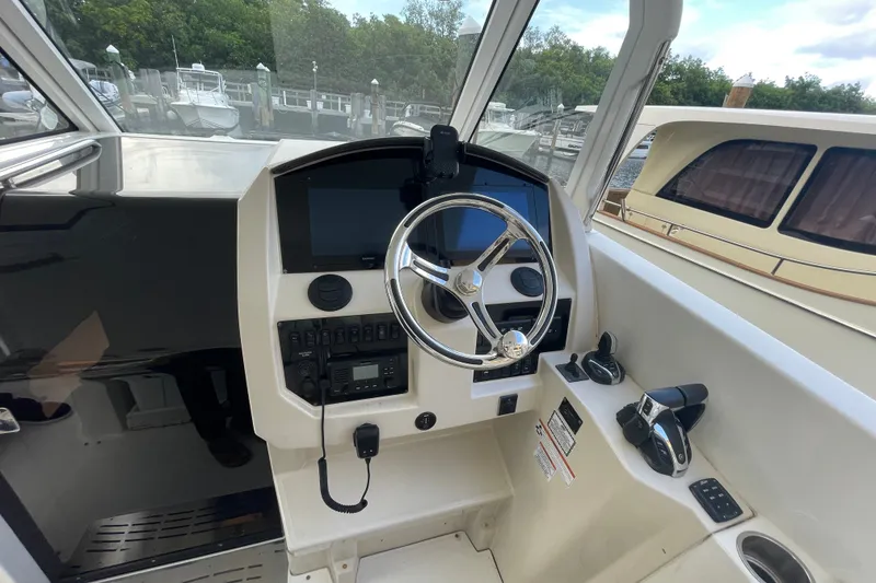 Slide: The Image of 2022 Regal 33 SAV boat helm with steering wheel and control panel. - 16