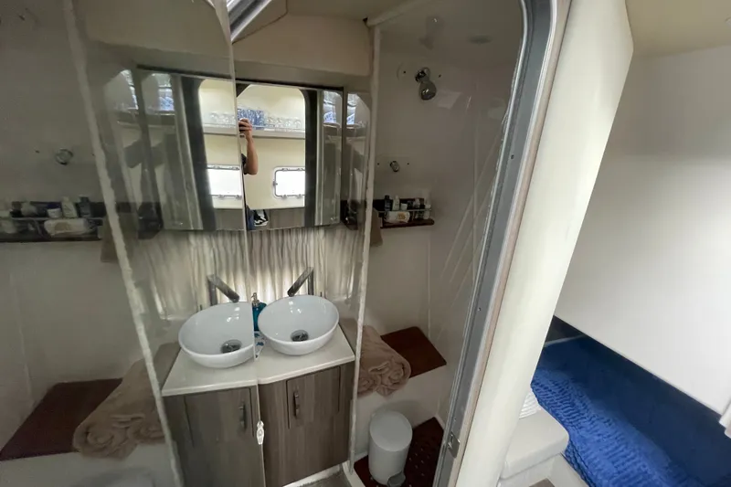 Slide: The Image of Luxurious bathroom interior of 2022 Regal 33 SAV yacht with dual sinks and mirrored cabinets. - 26