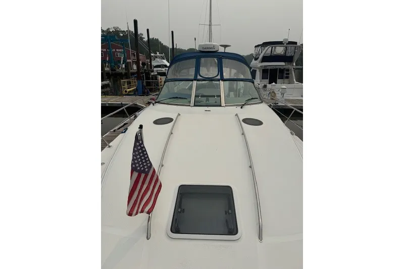 Slide: The Image of 2002 Sea Ray 360 Sundancer yacht with American flag, docked at marina. - 4