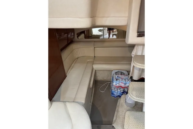Slide: The Image of Interior of 2002 Sea Ray 360 Sundancer with beige seating and storage space. - 16
