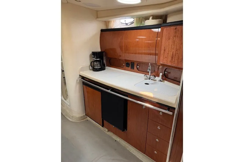 Slide: The Image of Interior of 2002 Sea Ray 360 Sundancer yacht kitchen with wood cabinetry and appliances. - 13