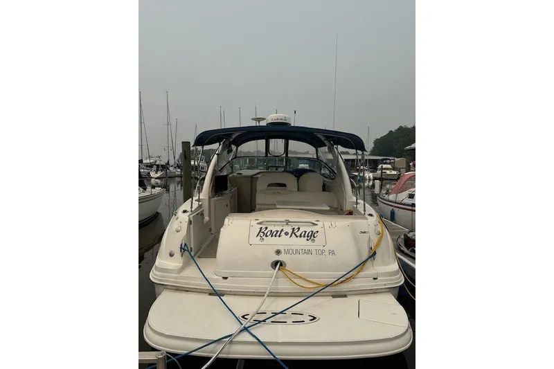 Slide: The Image of 2002 Sea Ray 360 Sundancer docked at marina, rear view with name "Boat Rage." - 1