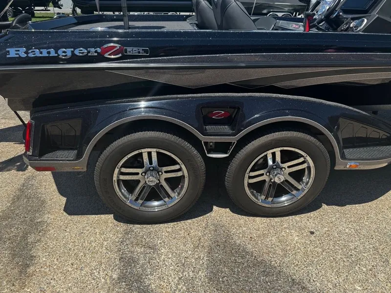 Slide: The Image of A 2021 Ranger Z521L boat with a dual-axle trailer and shiny rims. - 16