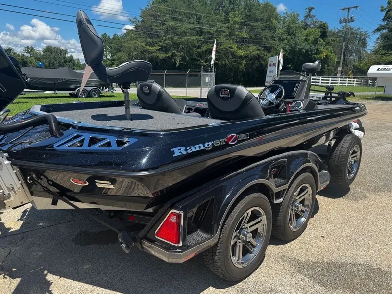Slide: The Image of A black 2021 Ranger Z521L boat is on a trailer outdoors. - 9