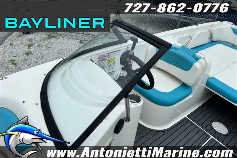 Slide: The Image of 2021 Bayliner Element E21 boat interior with blue and white seating, steering wheel, and dashboard. - 15