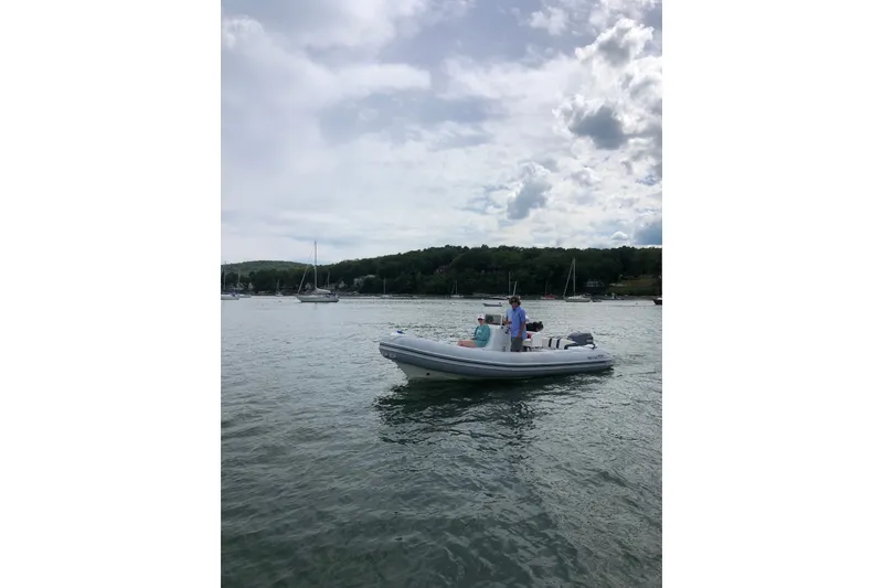 Slide: The Image of 2003 Nautica 22 Wide Body boat on calm water with scenic background. - 12