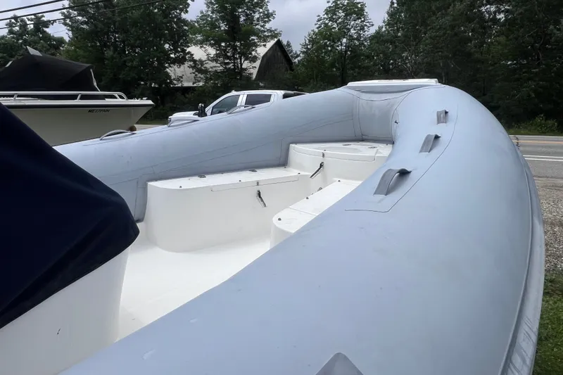 Slide: The Image of 2003 Nautica 22 Wide Body inflatable boat with spacious seating, parked outdoors. - 5