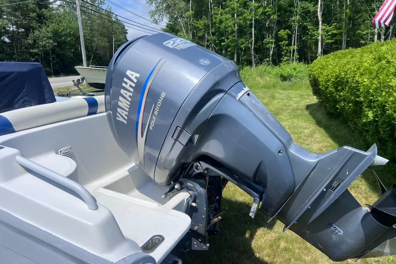 Slide: The Image of 2003 Nautica 22 Wide Body boat with Yamaha four-stroke outboard motor, parked on grass. - 4