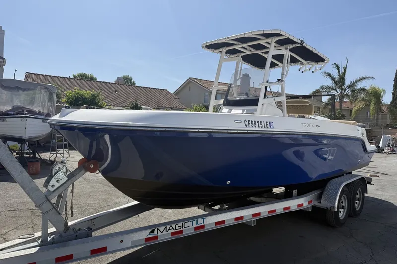 The Image of 2022 Bayliner Trophy T22CX boat on trailer, parked outdoors. - 1