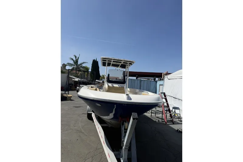 Slide: The Image of 2022 Bayliner Trophy T22CX boat on trailer under clear blue sky. - 6